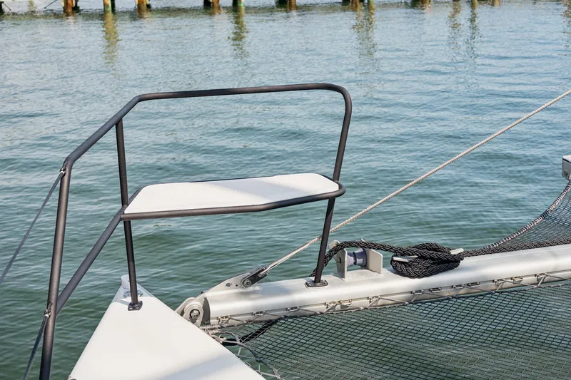 Slide: The Image of 2024 St Francis 460 catamaran bow with netting and railing over water. - 122