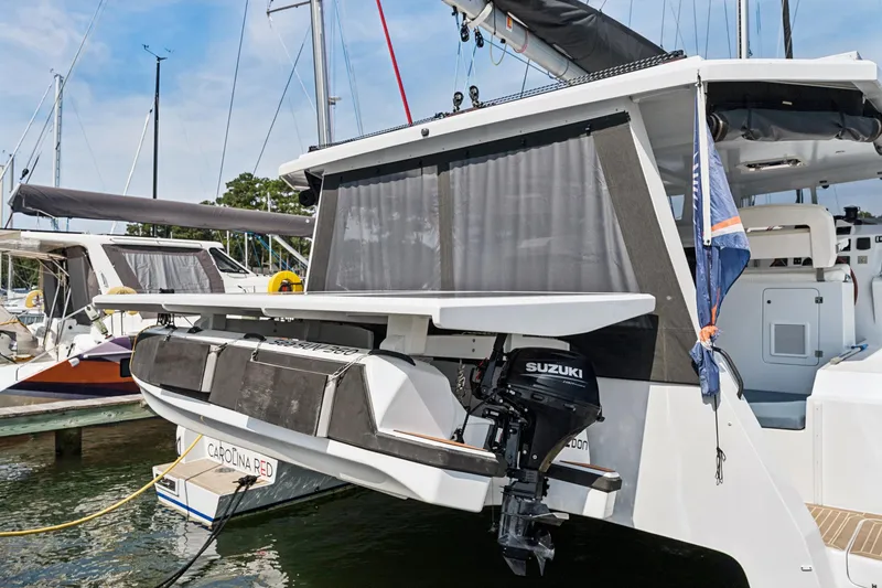 Slide: The Image of 2024 St Francis 460 catamaran with Suzuki outboard motor docked at marina. - 146