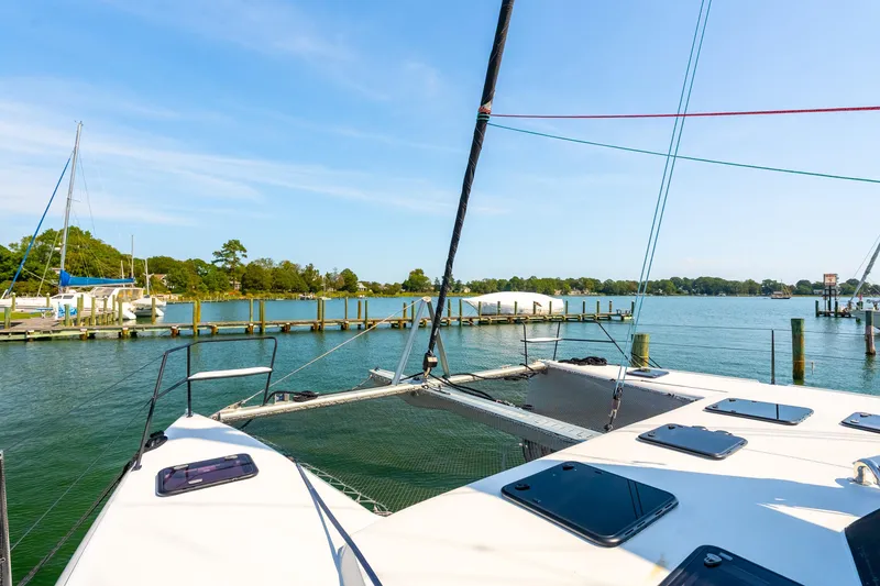Slide: The Image of 2024 St Francis 460 catamaran docked in a serene marina with clear blue skies. - 17