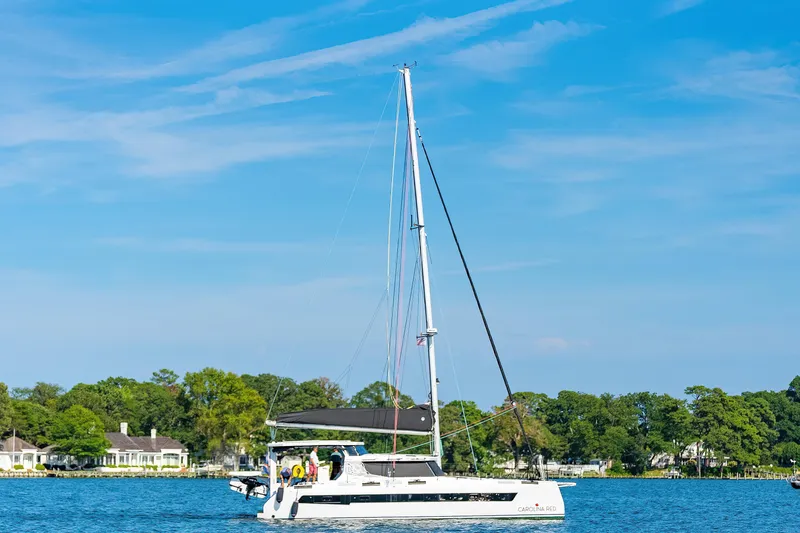 Slide: The Image of Sailing catamaran St Francis 460, 2024 model, cruising on a sunny day near lush shoreline. - 170