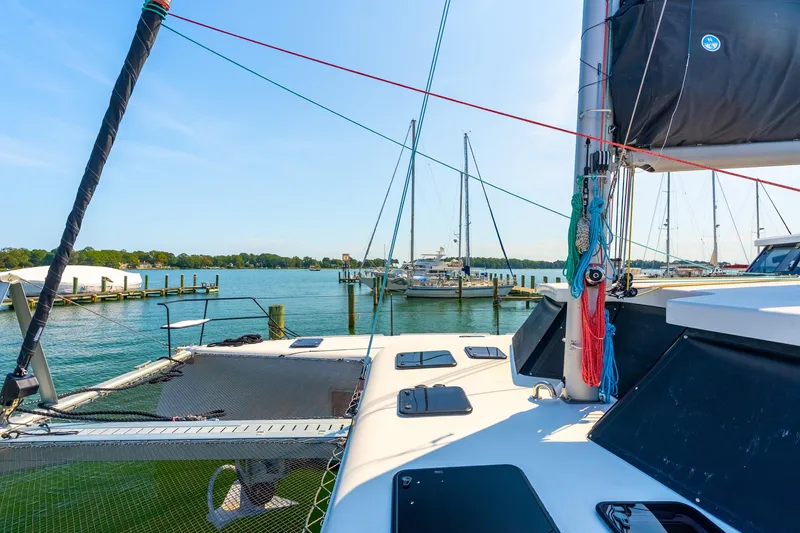 Slide: The Image of 2024 St Francis 460 catamaran docked in a scenic marina with clear blue skies. - 18