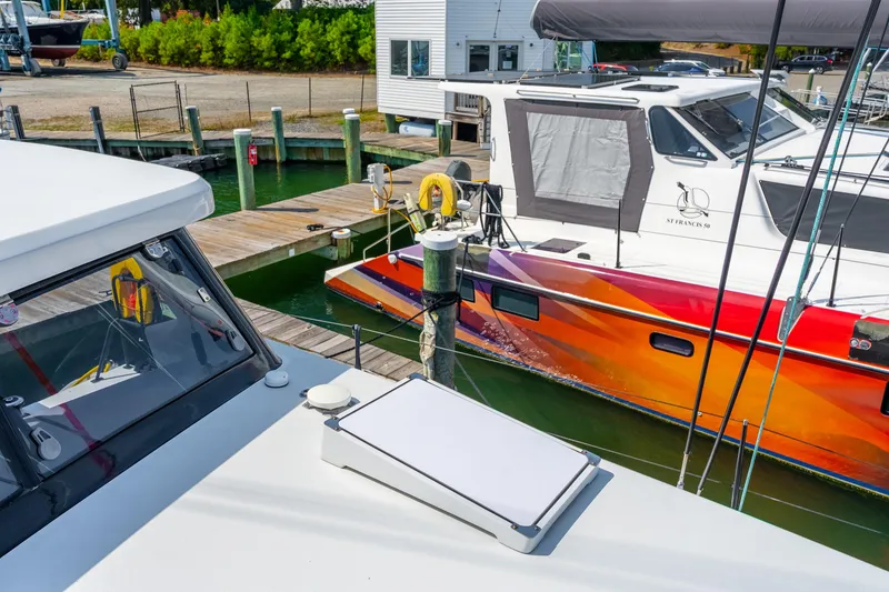 Slide: The Image of 2024 St Francis 460 catamaran docked, vibrant hull design, marina setting. - 24