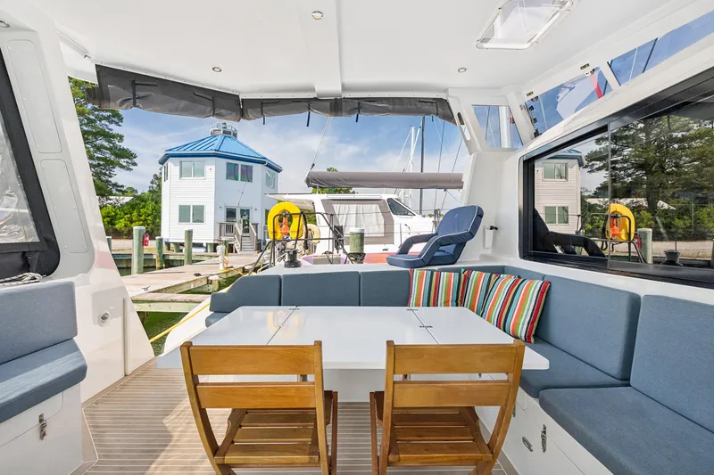 Slide: The Image of 2024 St Francis 460 yacht interior with seating, table, and marina view. - 31