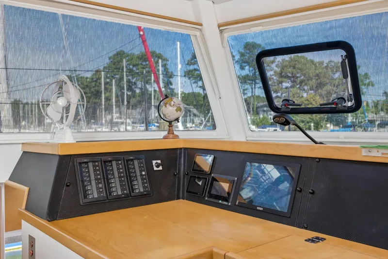 Slide: The Image of 2024 St Francis 460 yacht helm with navigation controls and fan, docked at marina. - 54