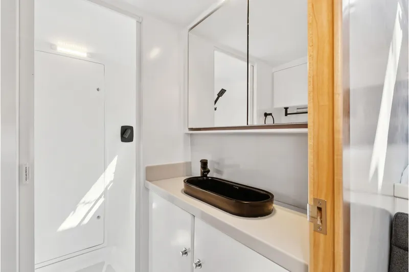 Slide: The Image of Modern bathroom in 2024 St Francis 460 yacht with sleek black sink and mirrored cabinets. - 78