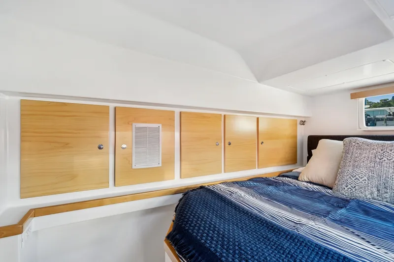 Slide: The Image of 2024 St Francis 460 interior cabin with wooden storage and cozy bedding. - 92