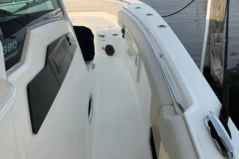 Slide: The Image of 2019 Boston Whaler 380 Outrage boat deck, sleek design, docked by water. - 11