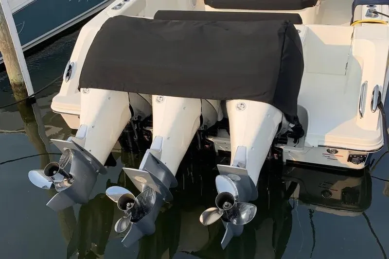 Slide: The Image of 2019 Boston Whaler 380 Outrage with triple outboard engines, docked in marina. - 12
