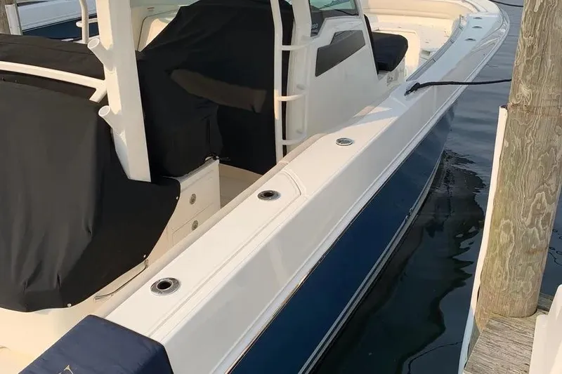 Slide: The Image of 2019 Boston Whaler 380 Outrage docked, featuring sleek design and covered seating. - 14