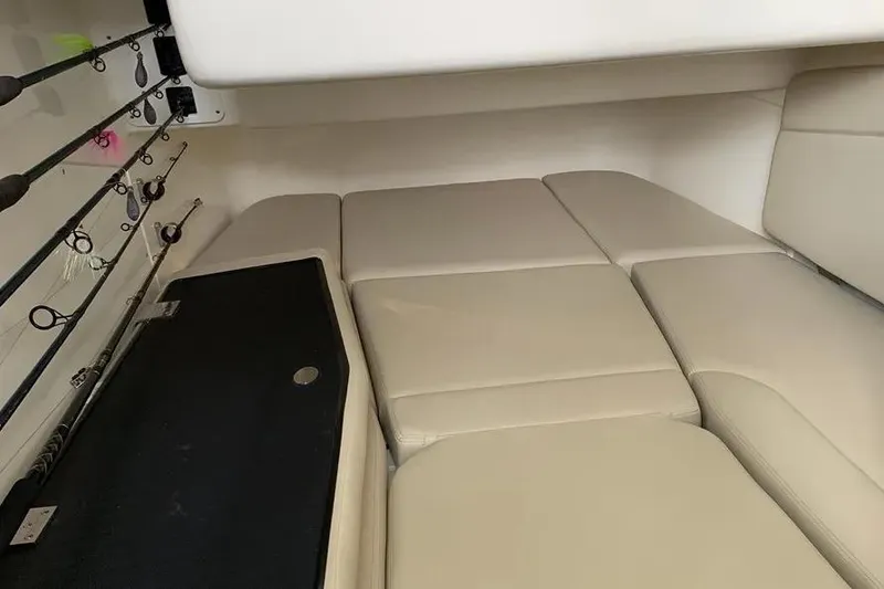 Slide: The Image of 2019 Boston Whaler 380 Outrage cabin with beige cushions and fishing rod storage. - 28