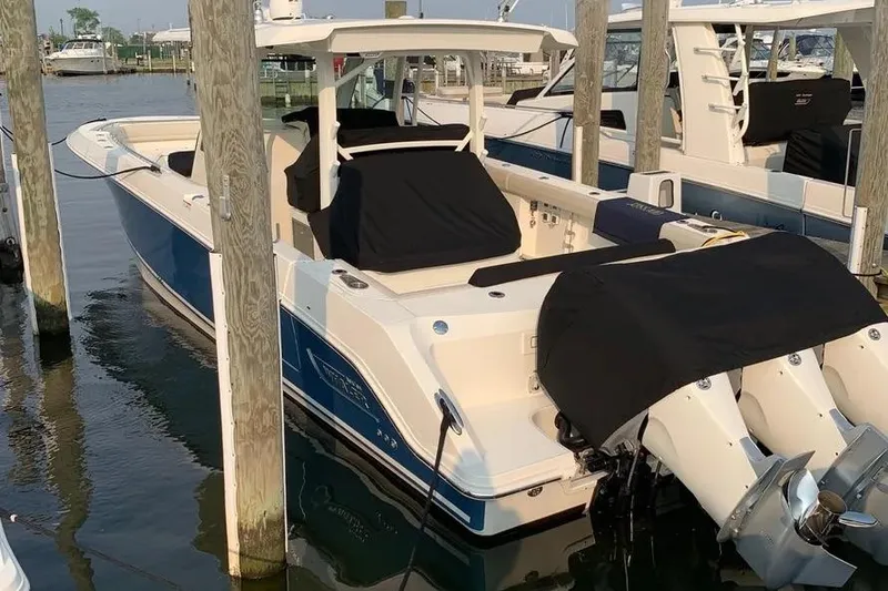 Slide: The Image of 2019 Boston Whaler 380 Outrage docked, featuring dual outboard engines and sleek design. - 35