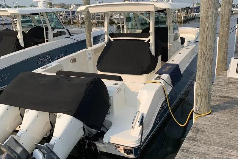 Slide: The Image of 2019 Boston Whaler 380 Outrage docked, featuring covered engines and sleek design. - 40