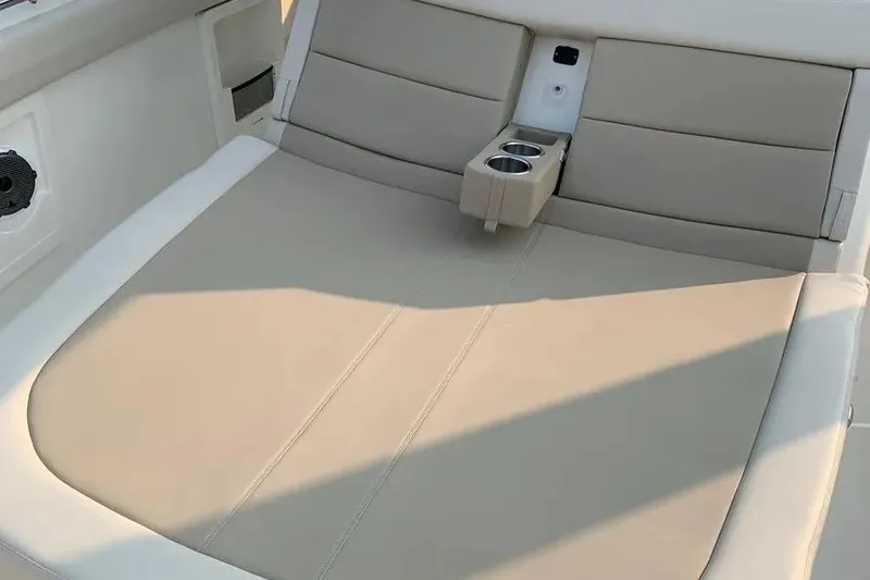 Slide: The Image of 2019 Boston Whaler 380 Outrage boat interior with beige seating and cup holders. - 44