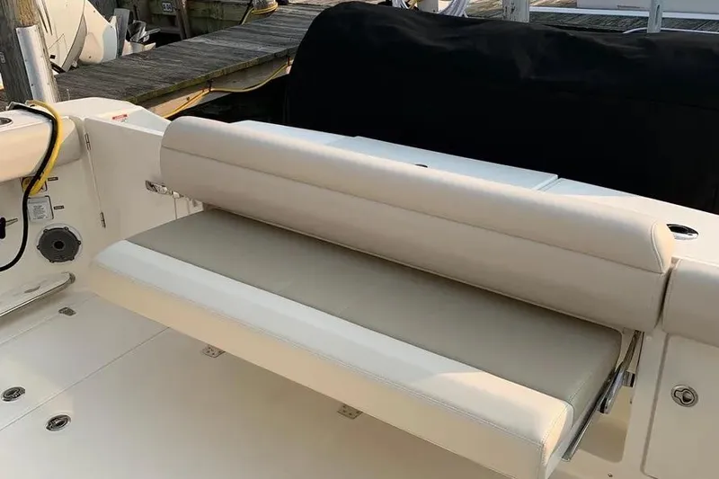 Slide: The Image of 2019 Boston Whaler 380 Outrage boat with beige seating and dockside view. - 50
