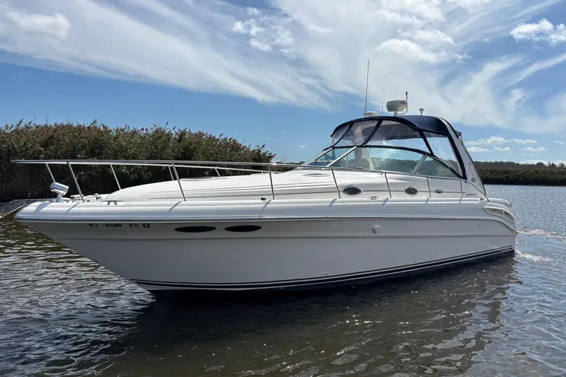 The Image of 2002 Sea Ray 340 Sundancer boat on calm water under a blue sky. - 0
