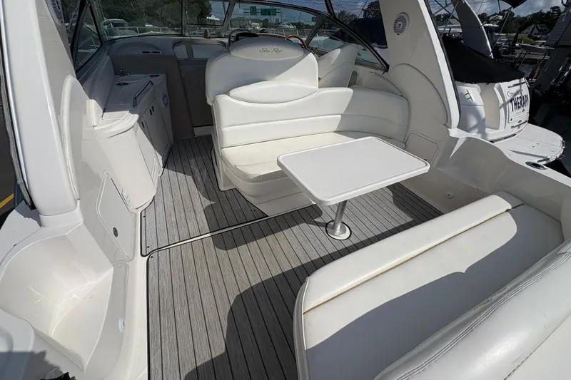 Slide: The Image of 2002 Sea Ray 340 Sundancer interior with white seating and table on deck. - 12