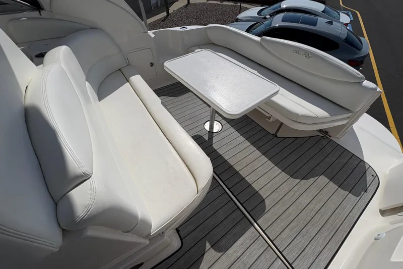 Slide: The Image of 2002 Sea Ray 340 Sundancer boat interior with white seating and table on deck. - 13
