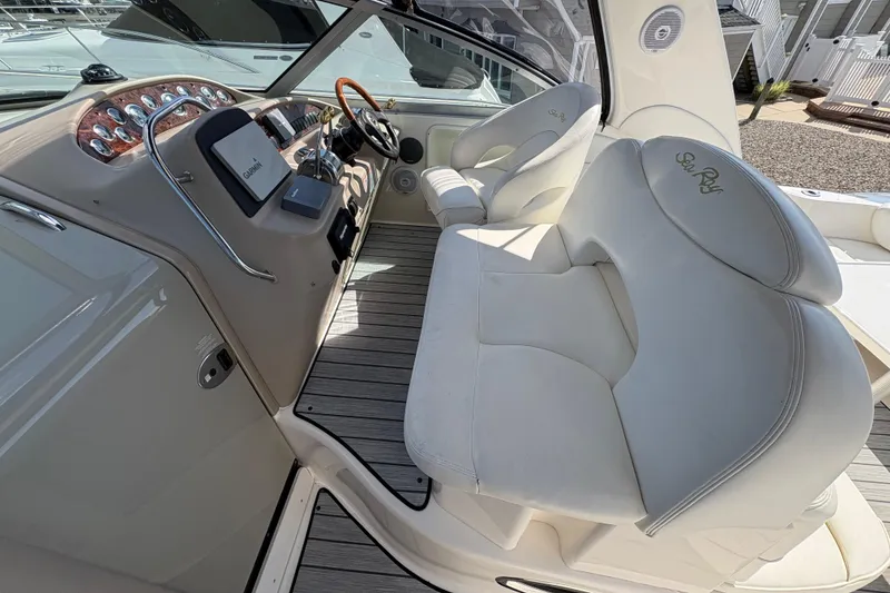 Slide: The Image of 2002 Sea Ray 340 Sundancer cockpit with white seating and modern dashboard. - 15