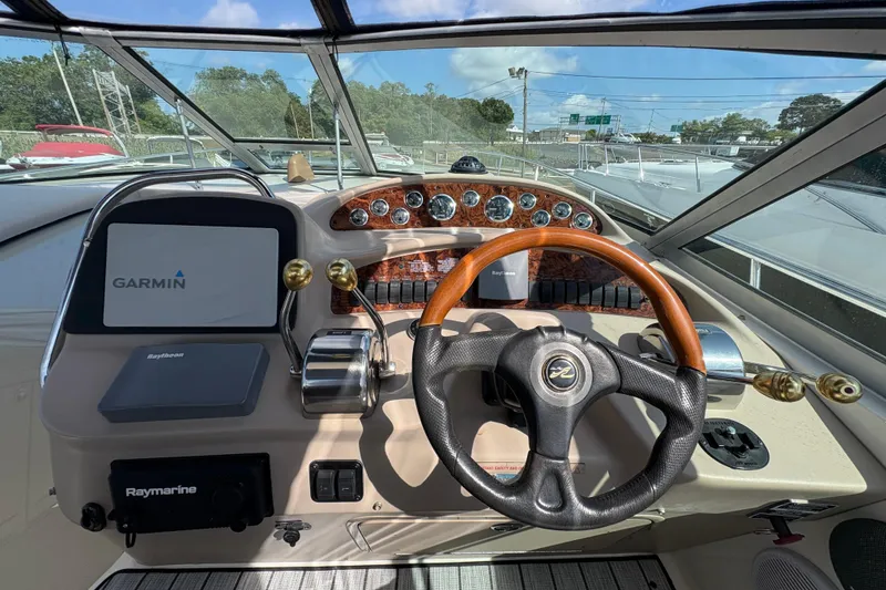 Slide: The Image of 2002 Sea Ray 340 Sundancer helm with Garmin navigation and wood-accented steering wheel. - 16