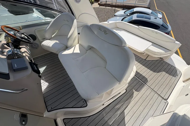 Slide: The Image of 2002 Sea Ray 340 Sundancer cockpit with white seating and wooden steering wheel. - 17