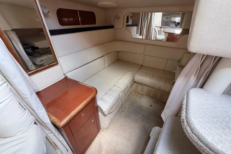 Slide: The Image of Interior of 2002 Sea Ray 340 Sundancer yacht with beige seating and wooden cabinetry. - 18