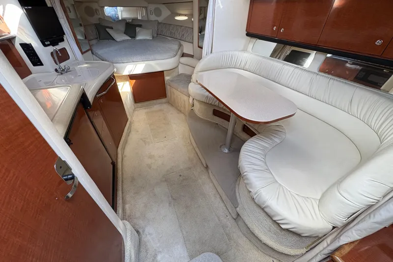 Slide: The Image of 2002 Sea Ray 340 Sundancer interior with kitchen, seating, and bed. Luxurious yacht cabin design. - 19