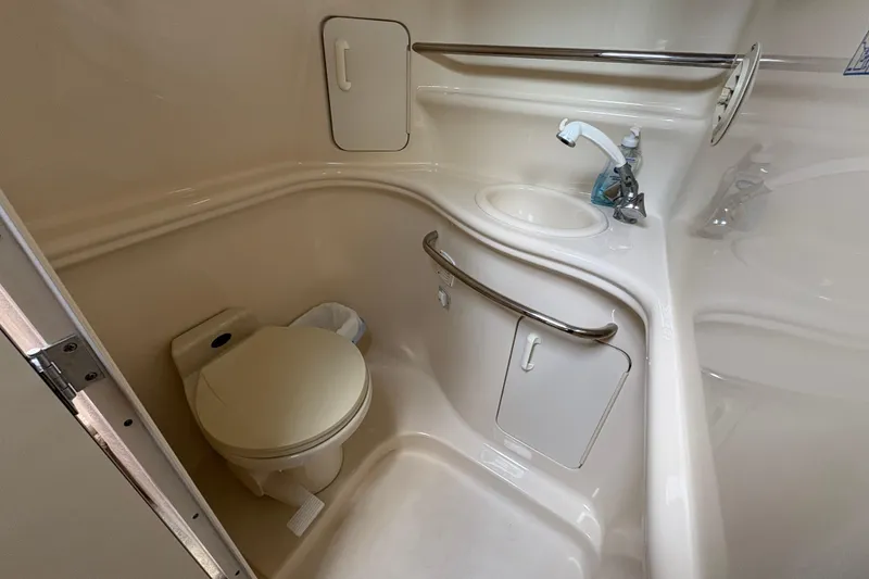Slide: The Image of 2002 Sea Ray 340 Sundancer bathroom with toilet, sink, and storage compartments. - 22