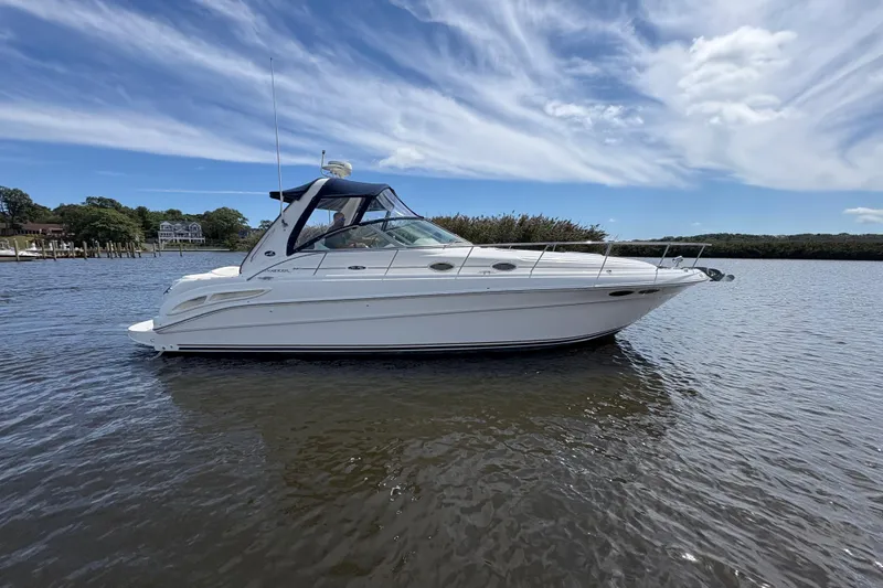 Slide: The Image of 2002 Sea Ray 340 Sundancer yacht on calm water under a partly cloudy sky. - 3