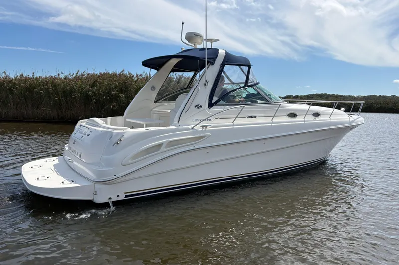 Slide: The Image of 2002 Sea Ray 340 Sundancer yacht on calm water, clear sky background. - 4