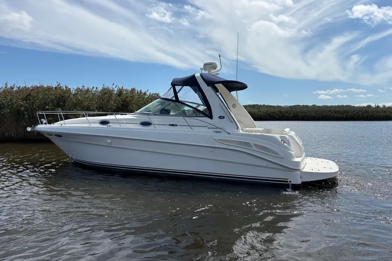 Slide: The Image of 2002 Sea Ray 340 Sundancer cruising on a calm river under a blue sky. - 7
