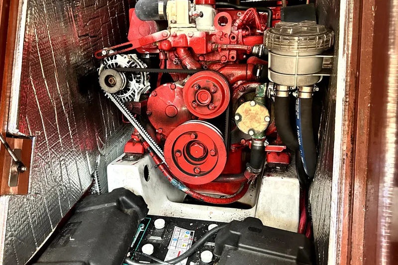 Slide: The Image of Engine compartment of a 2003 Beneteau Oceanis Clipper 473 sailboat, featuring a red engine. - 15