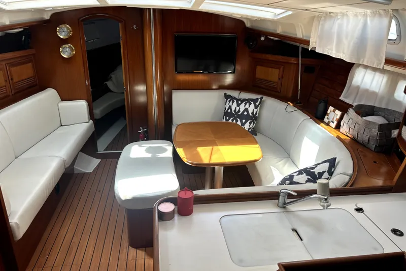 Slide: The Image of Interior of 2003 Beneteau Oceanis Clipper 473 yacht with elegant seating and wooden finishes. - 2