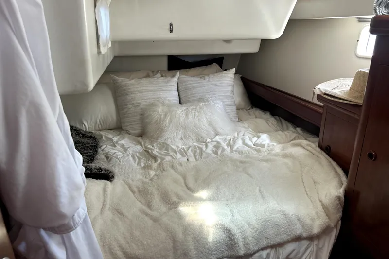 Slide: The Image of Cozy cabin interior of 2003 Beneteau Oceanis Clipper 473 with plush bedding and wooden accents. - 21