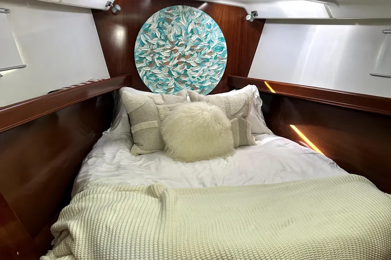 Slide: The Image of Cozy cabin interior of 2003 Beneteau Oceanis Clipper 473 with plush bedding and decorative art. - 4