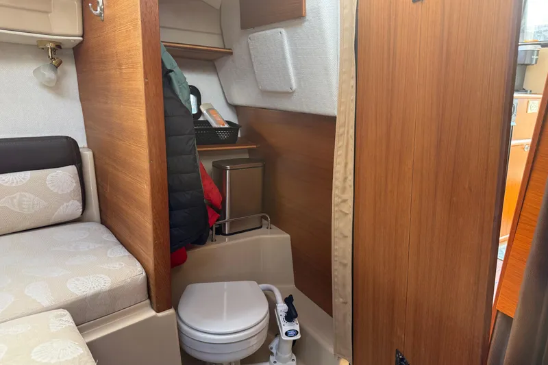 Slide: The Image of 2017 Ranger Tugs R-23 interior with compact toilet and cozy seating area. - 22