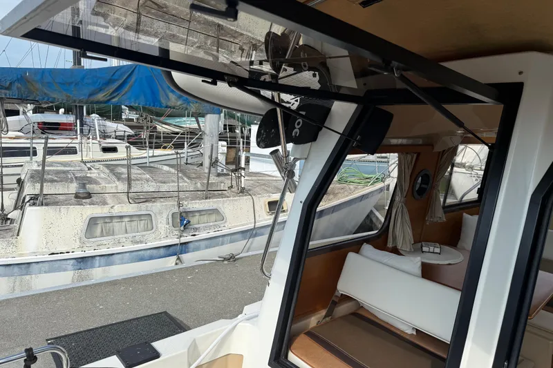 Slide: The Image of 2017 Ranger Tugs R-23 interior view with marina backdrop. - 26