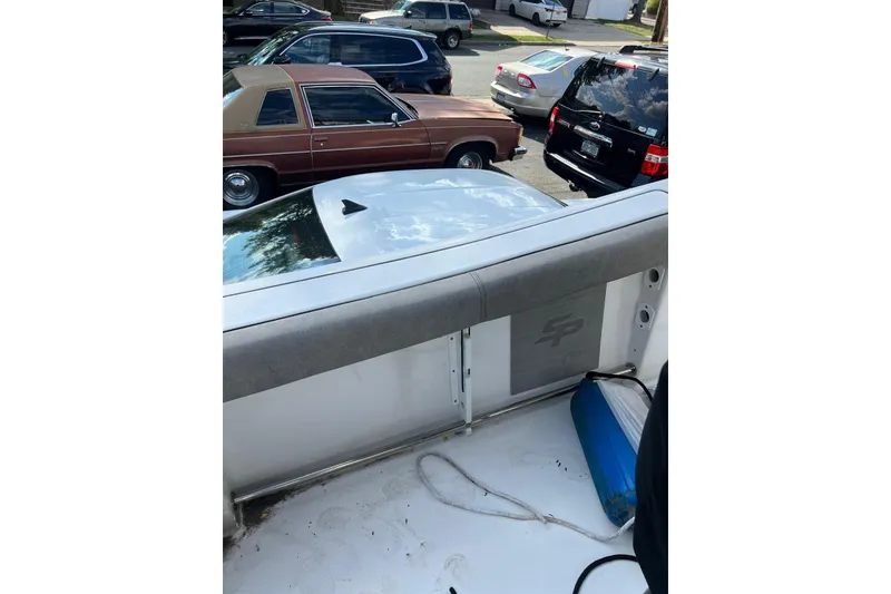 Slide: The Image of 2022 Sea Pro 239 Sport boat interior with parked cars in the background. - 19