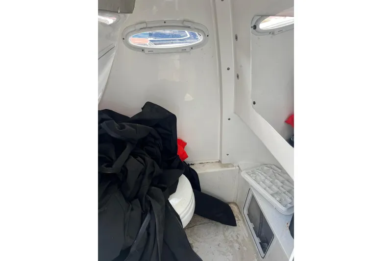 Slide: The Image of Interior of 2022 Sea Pro 239 Sport boat cabin with portholes and storage. - 15