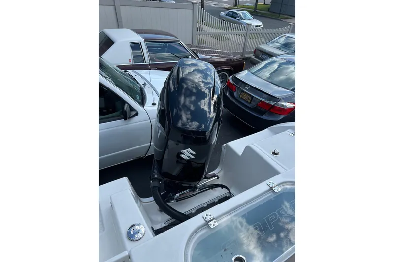 Slide: The Image of 2022 Sea Pro 239 Sport boat with Suzuki outboard motor, parked among cars. - 16