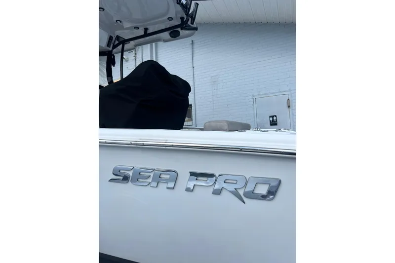Slide: The Image of 2022 Sea Pro 239 Sport boat with logo, parked near a white brick wall. - 3