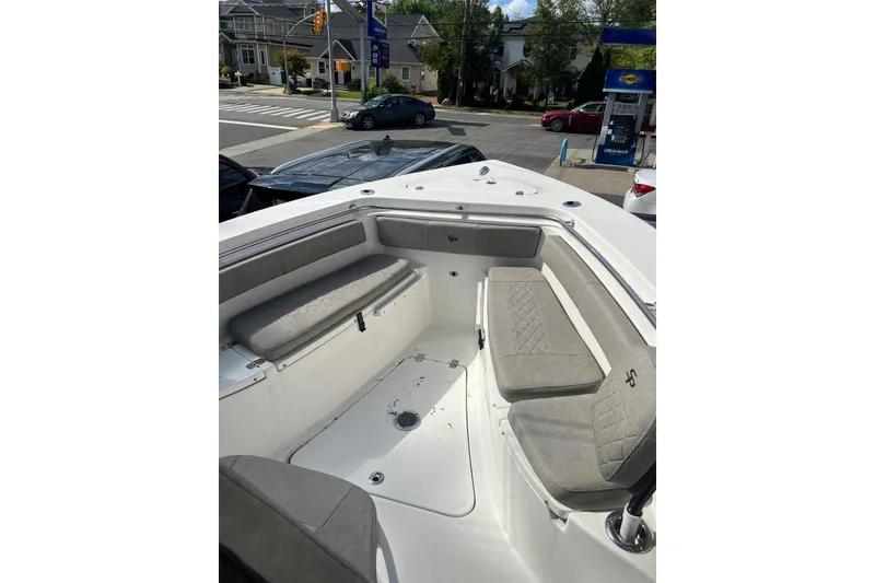 Slide: The Image of 2022 Sea Pro 239 Sport boat interior with cushioned seating at a gas station. - 7