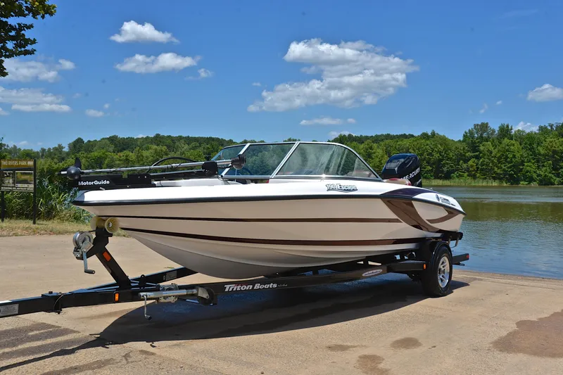 Slide: The Image of 2012 Triton 190 boat on trailer by a lake under a clear blue sky. - 10