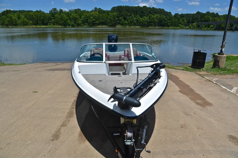 Slide: The Image of 2012 Triton 190 boat at a lakeside launch ramp on a sunny day. - 17