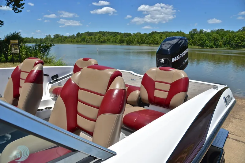 Slide: The Image of 2012 Triton 190 boat with red and beige seats by a scenic lake. - 18