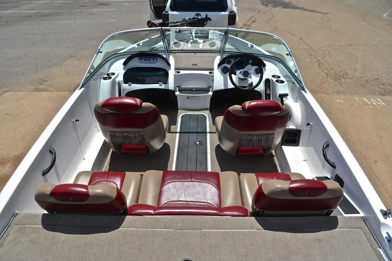 Slide: The Image of 2012 Triton 190 boat interior with red and beige seating, steering wheel, and dashboard. - 20