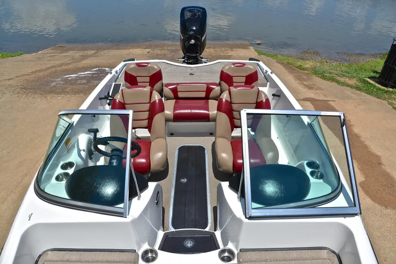 Slide: The Image of 2012 Triton 190 boat with red and beige seating, docked by the water. - 22