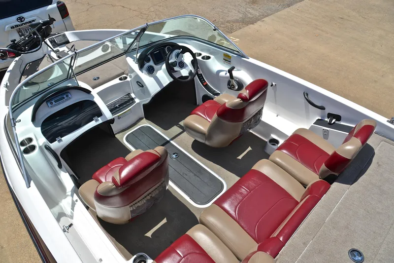 Slide: The Image of 2012 Triton 190 boat interior with red and beige seating, steering console, and spacious layout. - 23