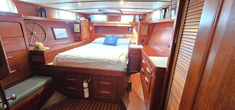 Slide: The Image of Interior of 1980 Gulfstar 47 Sailmaster with wood cabinetry and cozy sleeping area. - 12