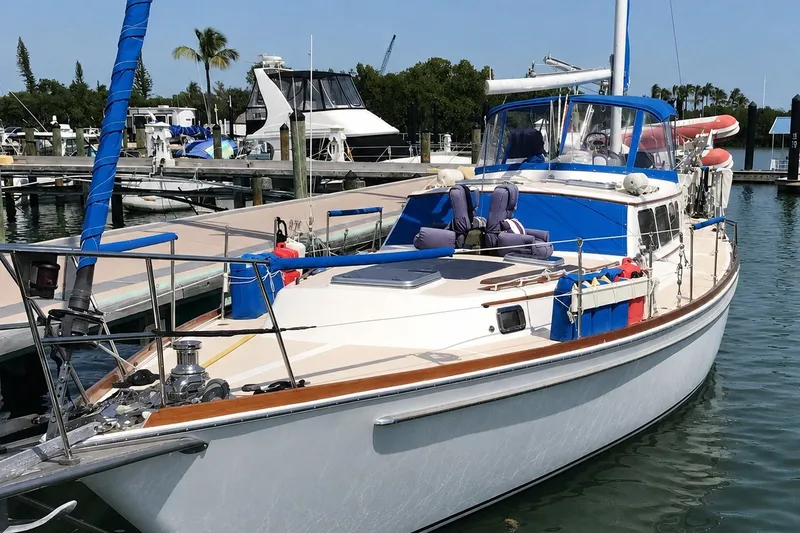 The Image of 1980 Gulfstar 47 Sailmaster docked at marina, featuring blue accents and spacious deck. - 0