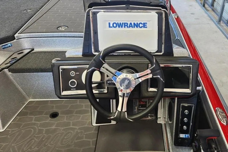 Slide: The Image of 2026 Ranger Z520R Cup-Equipped boat dashboard with Lowrance display and steering wheel. - 2